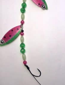 Bright watermelon glow fishing lure with double blades and gold backing for enhanced visibility.