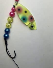 Brightly colored fishing lure with beads and hook for freshwater fishing.