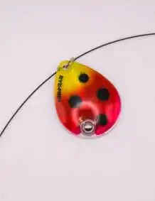 Colorful fishing lure with black spots, ideal for freshwater and saltwater fishing.