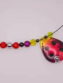 Fishing lure with colorful beads and a ladybug design for premium fishing tackle.
