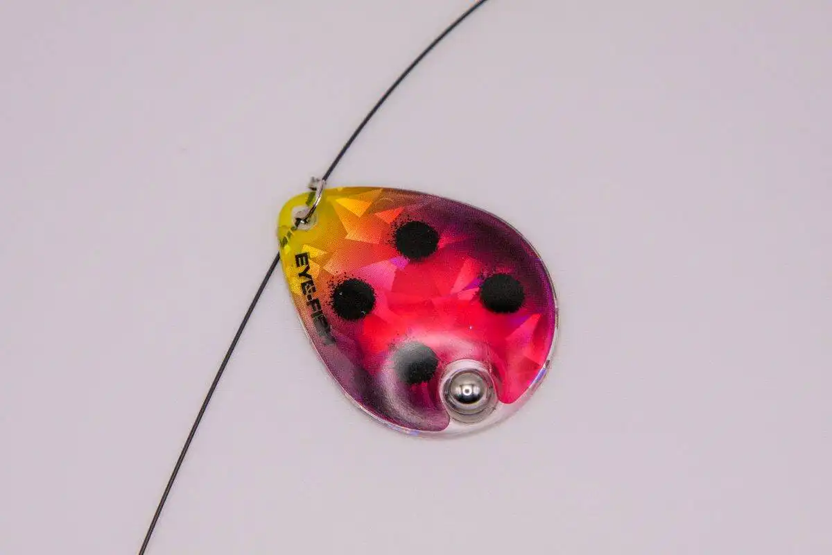 Colorful fishing lure with black spots for bass and trout fishing.