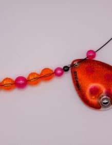 Fishing tackle jewelry with colorful beads and a red pendant.