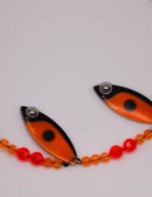Fishing lure with orange and black design, beads, and hook for freshwater and saltwater fishing.